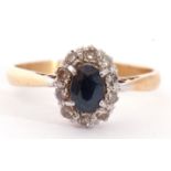 Sapphire and diamond cluster ring, the oval shaped faceted sapphire raised above a small diamond
