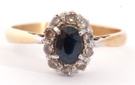 Sapphire and diamond cluster ring, the oval shaped faceted sapphire raised above a small diamond