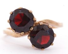 9ct gold and garnet cross over ring featuring two round faceted cut garnets, multi-claw set in