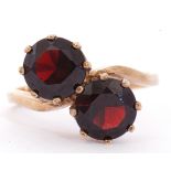 9ct gold and garnet cross over ring featuring two round faceted cut garnets, multi-claw set in