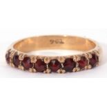 9ct gold and garnet set ring featuring eight round faceted garnets, line set, size O/P