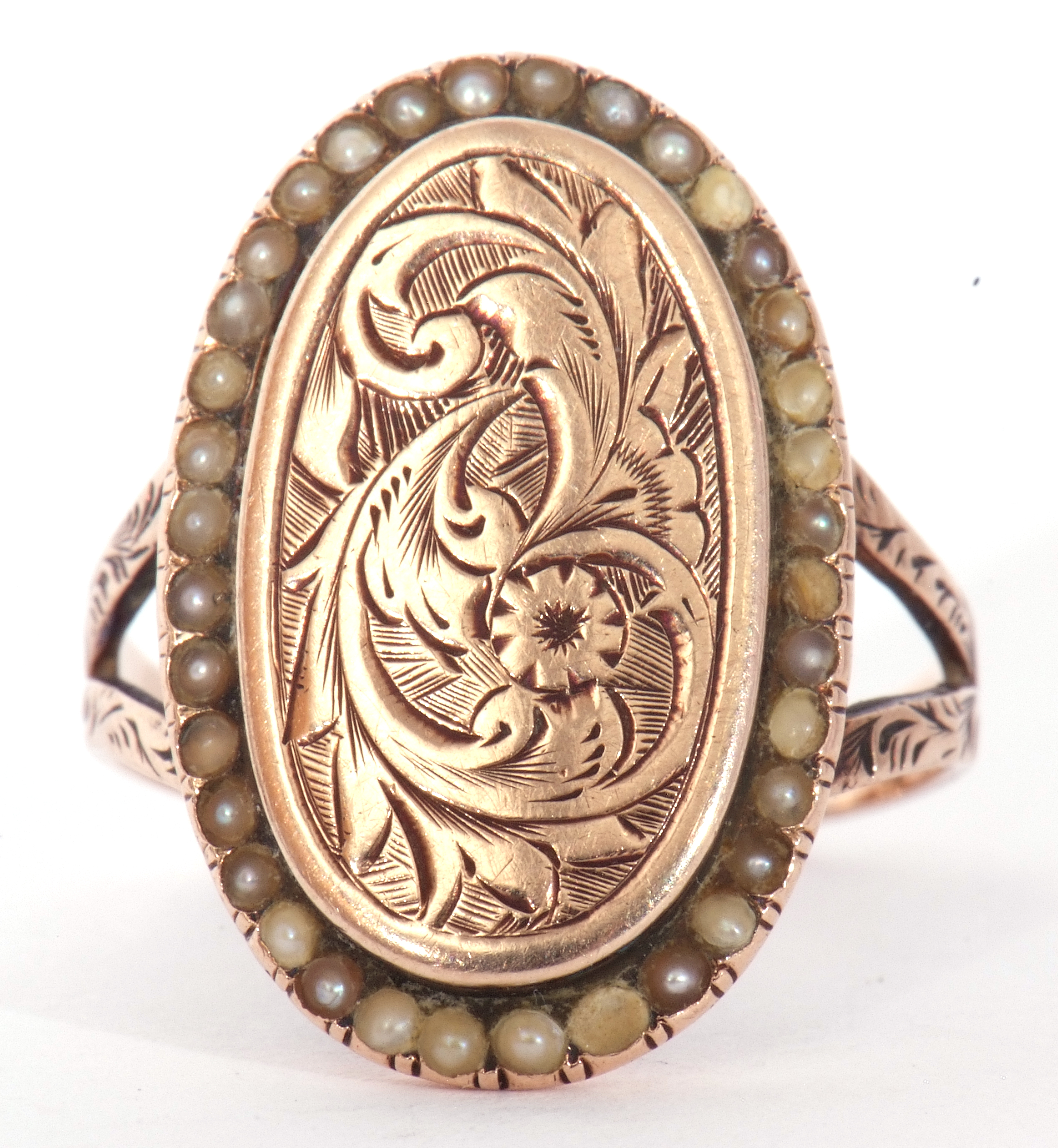 Antique yellow metal and pearl set ring, the oval panel engraved and chased with flowers and