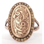 Antique yellow metal and pearl set ring, the oval panel engraved and chased with flowers and