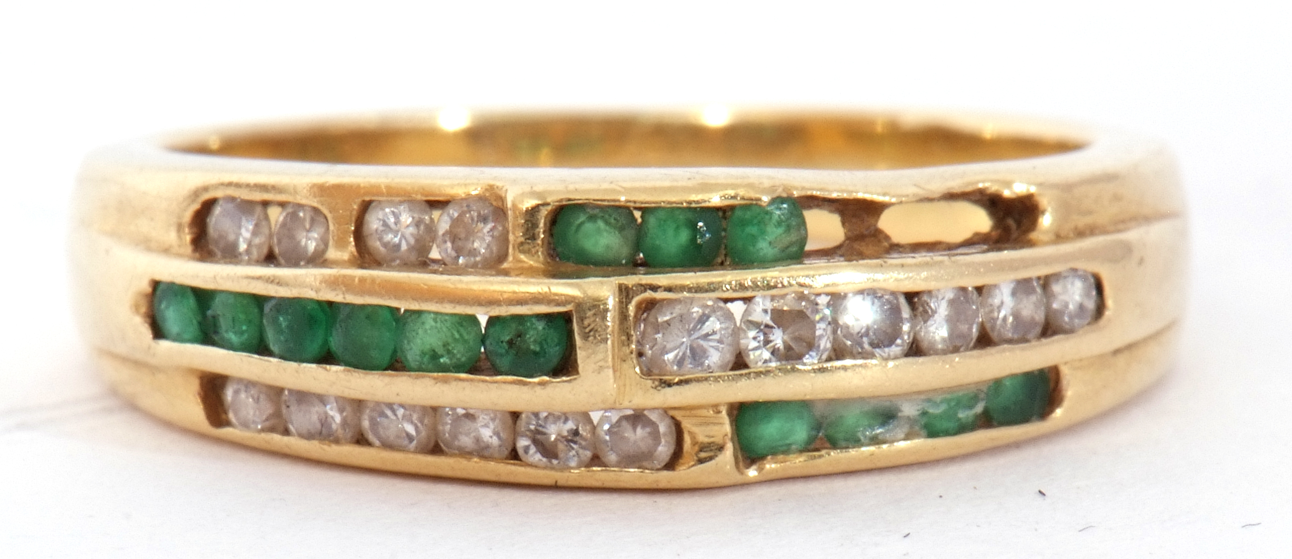 Emerald and diamond set half hoop ring, an Art Deco design of three bands of channel set diamonds