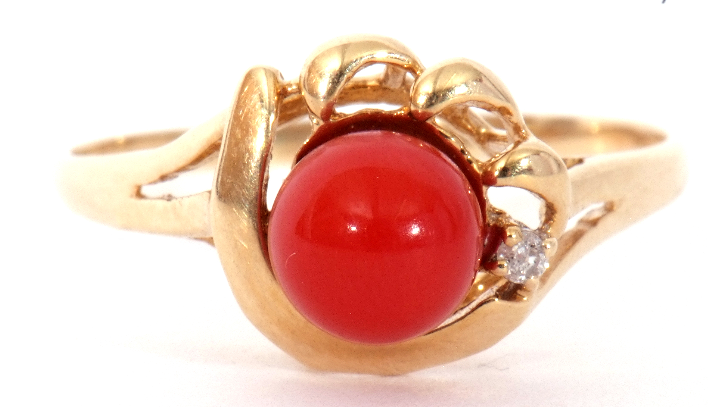 Vintage coral bead and small diamond set ring, the coral bead raised between pierced scroll and