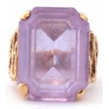 Modern large light purple stone dress ring, featuring a stepped cut purple stone, four claw set