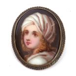 Vintage porcelain painted oval brooch depicting a head and shoulders portrait of a young lady,