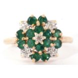 Modern yellow metal diamond and emerald cluster ring, a flowerhead design, all set and raised in a