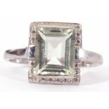 9ct gold and pale blue stone and diamond set ring, the step cut stone raised with a small diamond
