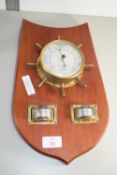 BAROMETER IN A METAL FRAME, MODELLED AS A SHIPS HELM ON WOODEN MOUNT TOGETHER WITH A THERMOMETER AND