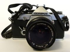 Olympus OM-2 film camera together with Olympus Zuiko 28mm lens and case