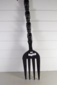 LARGE WOODEN FORK MODELLED AS A TOTEM POLE WITH CARVED HEADS