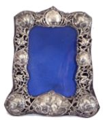 Late Victorian silver photograph frame with pierced and embossed border, decorated with cherubs,