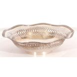 George V silver dish having pierced sides and reeded wavy rim and raised on a circular foot,