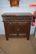 Oak side cabinet of panelled construction, with carved linenfold doors and carved frieze