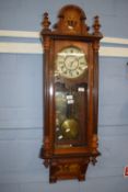 19th century wall clock with arch pediment and inlaid floral decoration enclosing a plain white dial