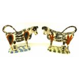 Pair of 19th century cow creamers with black sponged decoration with ochre patches, on sponged