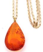 Amber drop pendant suspended on a 375 stamped chain, the pendant 4 x 2cm, chain 5.4gms