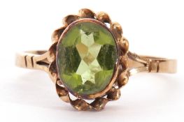 9ct gold peridot single stone ring, the oval faceted peridot 8x6mm, bezel set in a rope twist mount,