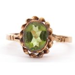 9ct gold peridot single stone ring, the oval faceted peridot 8x6mm, bezel set in a rope twist mount,