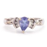 Modern 9ct white gold blue coloured stone and diamond ring, the pear shaped centre stone flanked