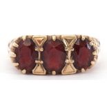 9ct gold and garnet three stone ring featuring three graduated oval faceted garnets, each