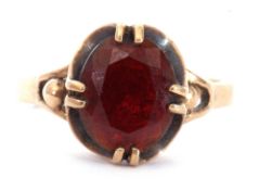 9ct gold garnet set ring, the oval faceted garnet cardinal set raised above plain polished shank,