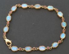 Modern 9ct gold opal and small ruby bracelet featuring 13 oval shaped opals in cut downs settings,