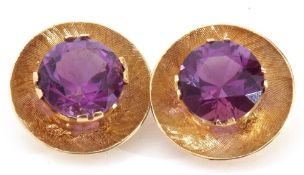 Pair of 585 stamped amethyst earrings, the burnished disc shaped settings each centring a raised