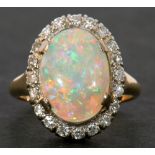 Opal and diamond cluster ring, the oval shaped cabochon opal 14 x 10mm approx, surrounded by 20