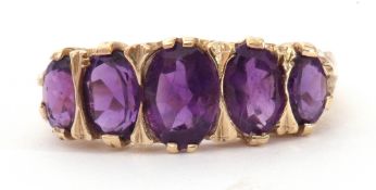 9ct gold amethyst five stone ring, featuring five graduated oval shaped amethysts, all in a carved