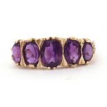 9ct gold amethyst five stone ring, featuring five graduated oval shaped amethysts, all in a carved