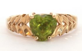 Modern 585 stamped peridot set ring, the heart shaped peridot raised above pierced textured