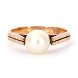 9ct stamped and cultured pearl ring, a single full pearl raised between upswept shoulders to an