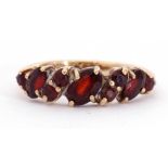 9ct gold garnet ring, alternate set with oval and round shaped small garnets, each individually claw