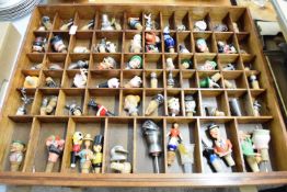 LARGE WOODEN DISPLAY CASE WITH QTY OF BOTTLE STOPPERS, SOME CERAMIC MODELS, FIGURAL HEADS, METAL
