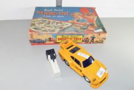 Vintage boxed remote control driving test together with a plastic model of a Porsche race car