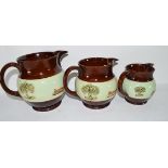 Graduated group of three Bourne Denby pottery jugs, all decorated with a sprigged hunting design (