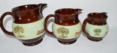 Graduated group of three Bourne Denby pottery jugs, all decorated with a sprigged hunting design (