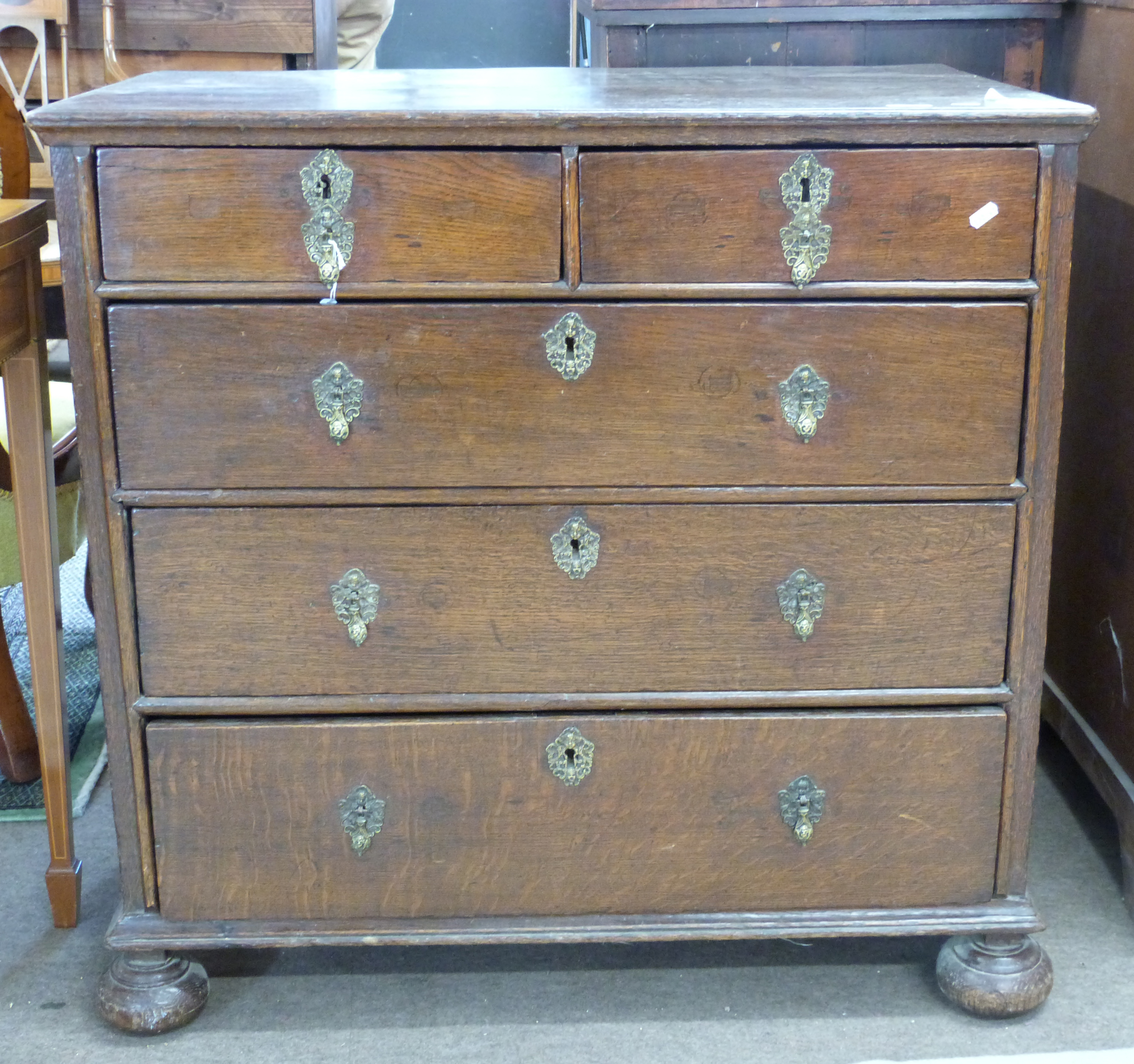 18th century oak chest of two short over three long drawers, raised on bun feet with decorative