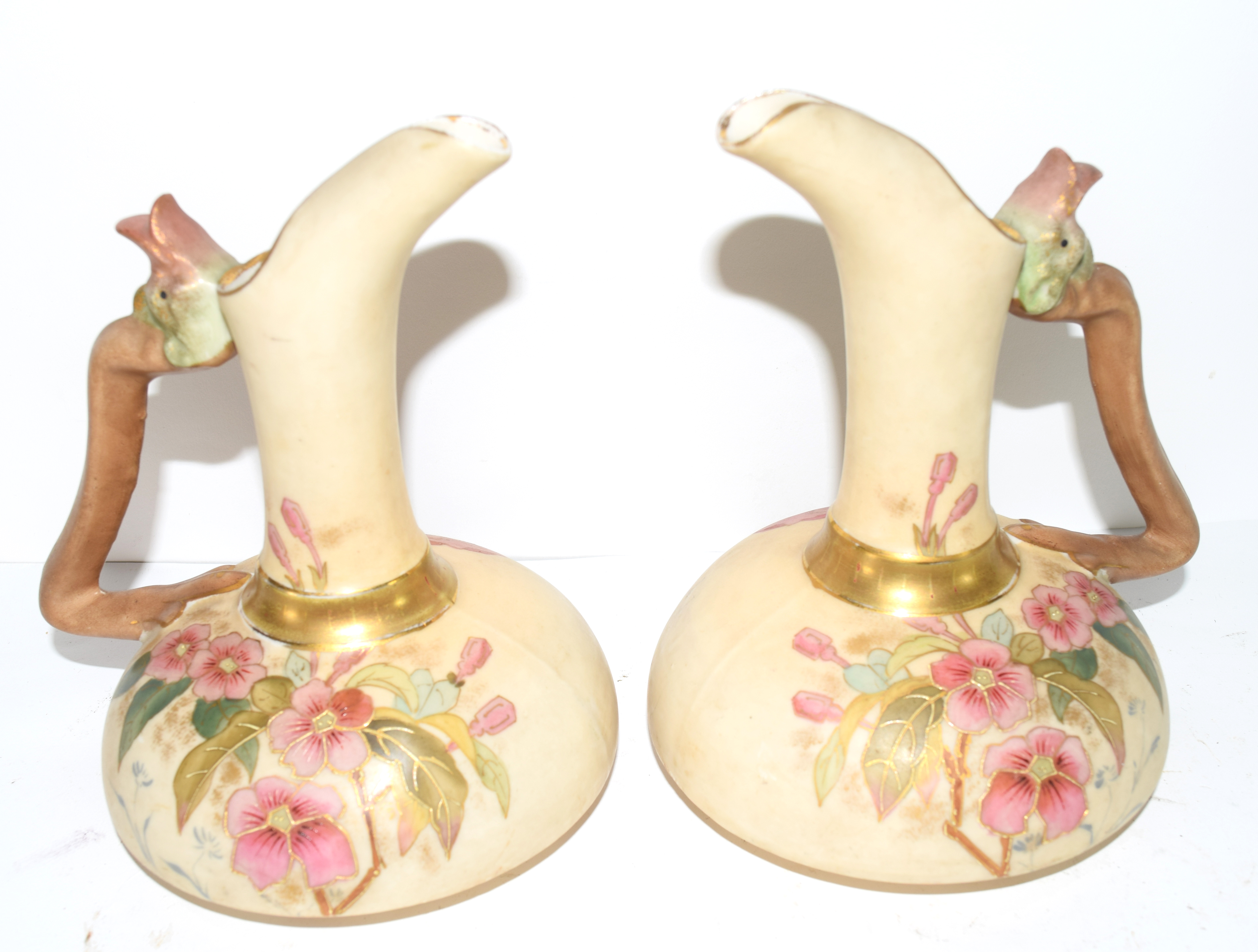 Pair of Continental ewers modelled in Royal Worcester style with the blush ground with floral