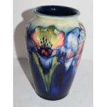 Moorcroft vase with tube lined decoration of an orchid on green and blue ground, 16cm high