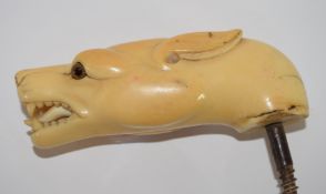 Ivory walking cane handle modelled as a dog's head with glass eyes, 10cm long