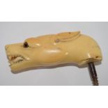 Ivory walking cane handle modelled as a dog's head with glass eyes, 10cm long