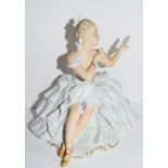 Continental porcelain model of a seated ballerina, 27cm high