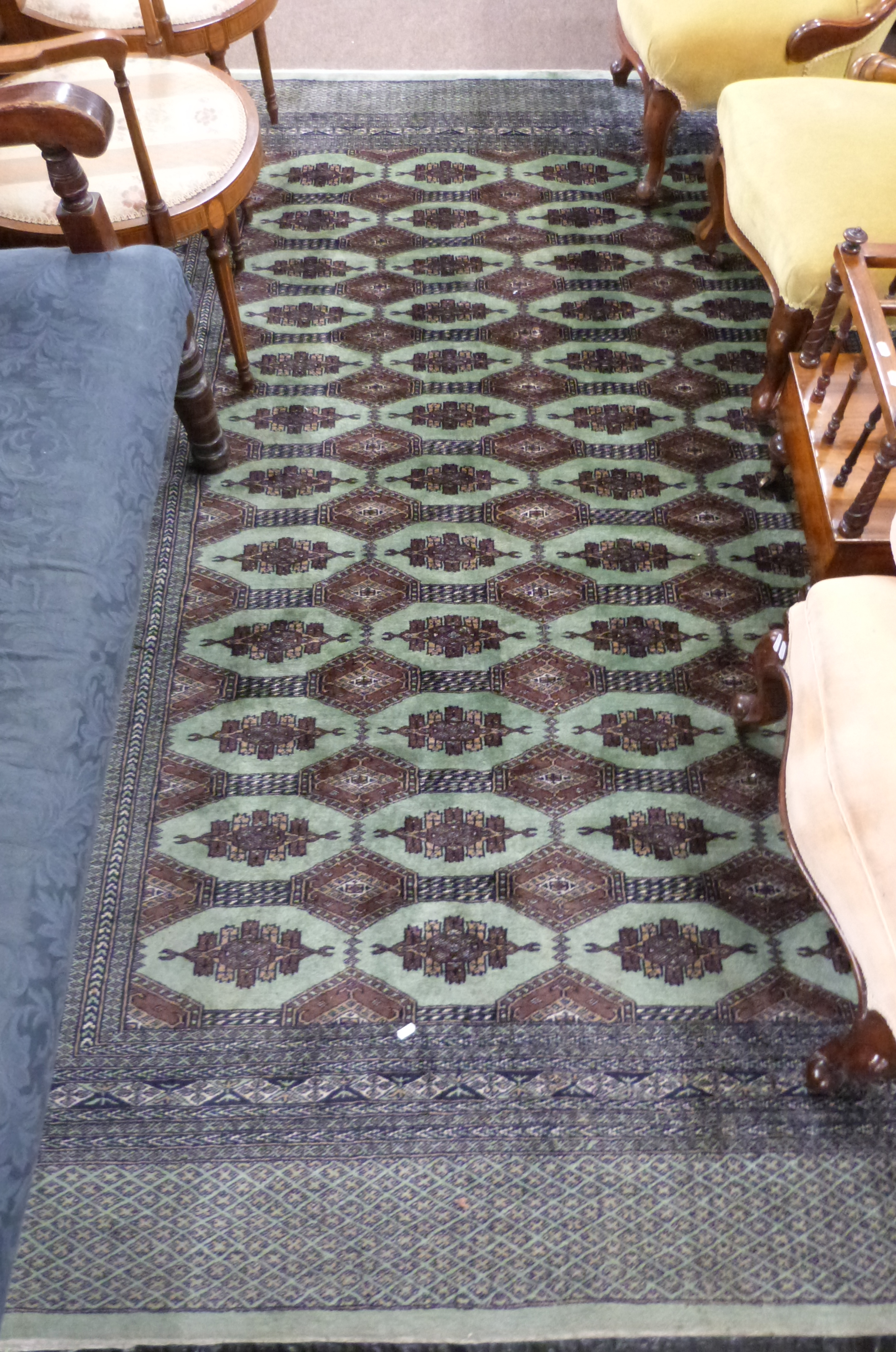 Green and Brown patterned wool carpet, decorated with medallions and a gulled border, 9ft x 5ft8