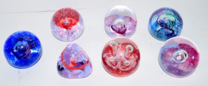 Quantity of seven small paperweights with various designs