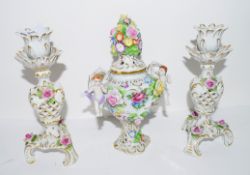 Pair of Continental porcelain candlesticks and a small vase with cover with applied flowers, the