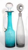 Two Art glass decanters with stoppers, one a smoky black colour, the other green with handle (2)