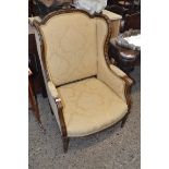 LATE 19TH CENTURY CONTINENTAL WING BACK ARMCHAIR WITH CARVED SHOW WOOD FRAME, UPHOLSTERED IN FLORAL